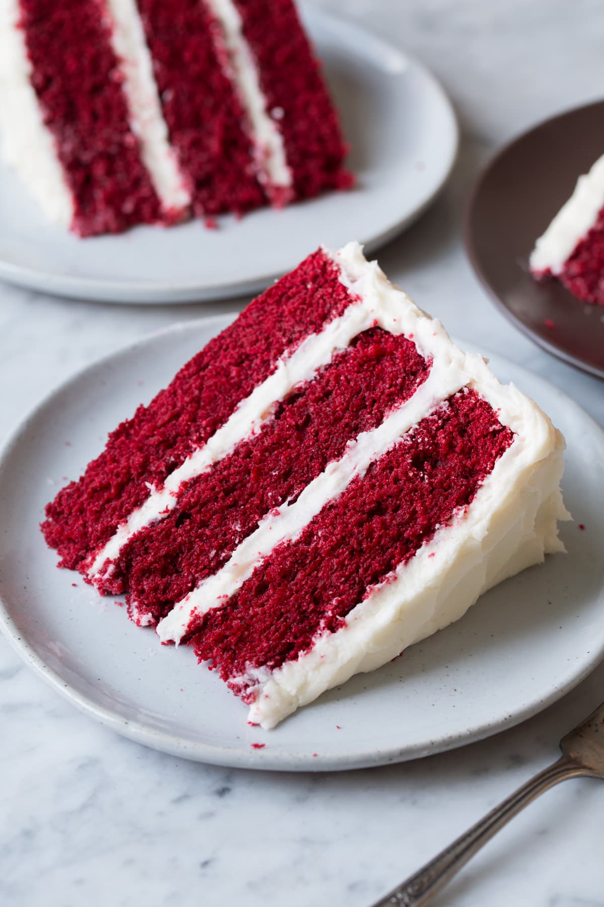 Single slice on a serving plate with two second slices in the background.