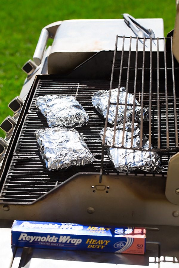 Four shrimp boil packs on the grill.