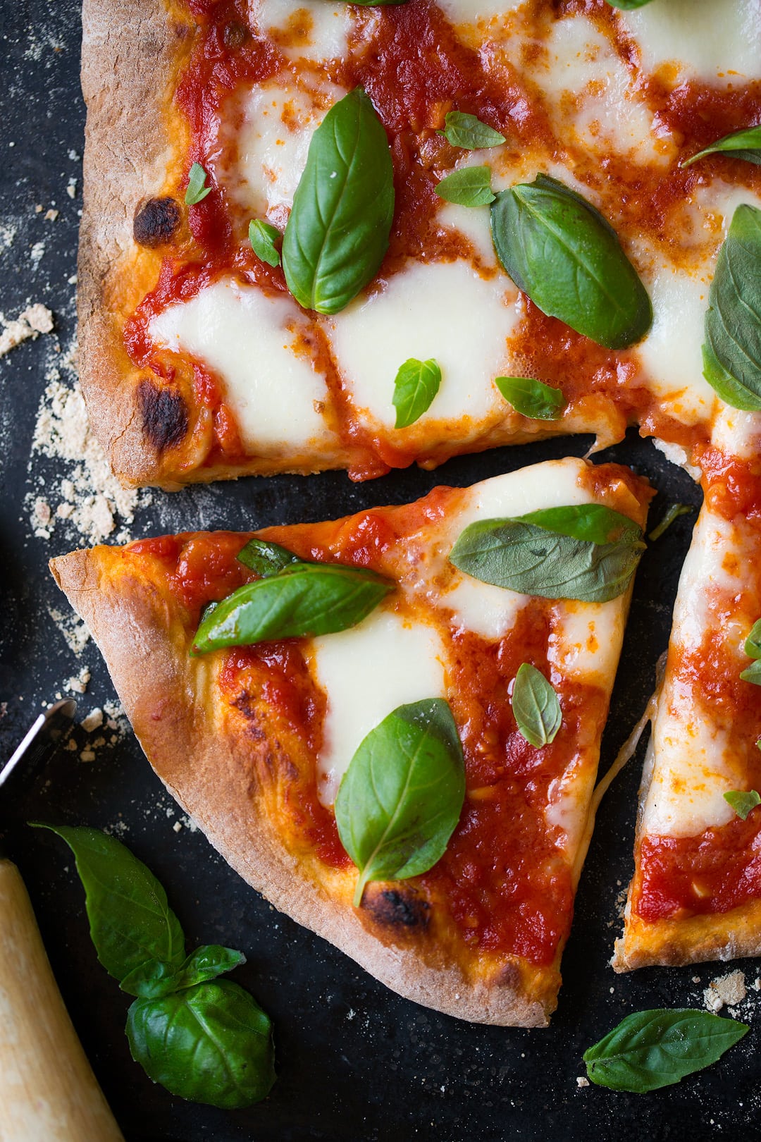 close up shot of homemade Margherita Pizza topped with fresh basil