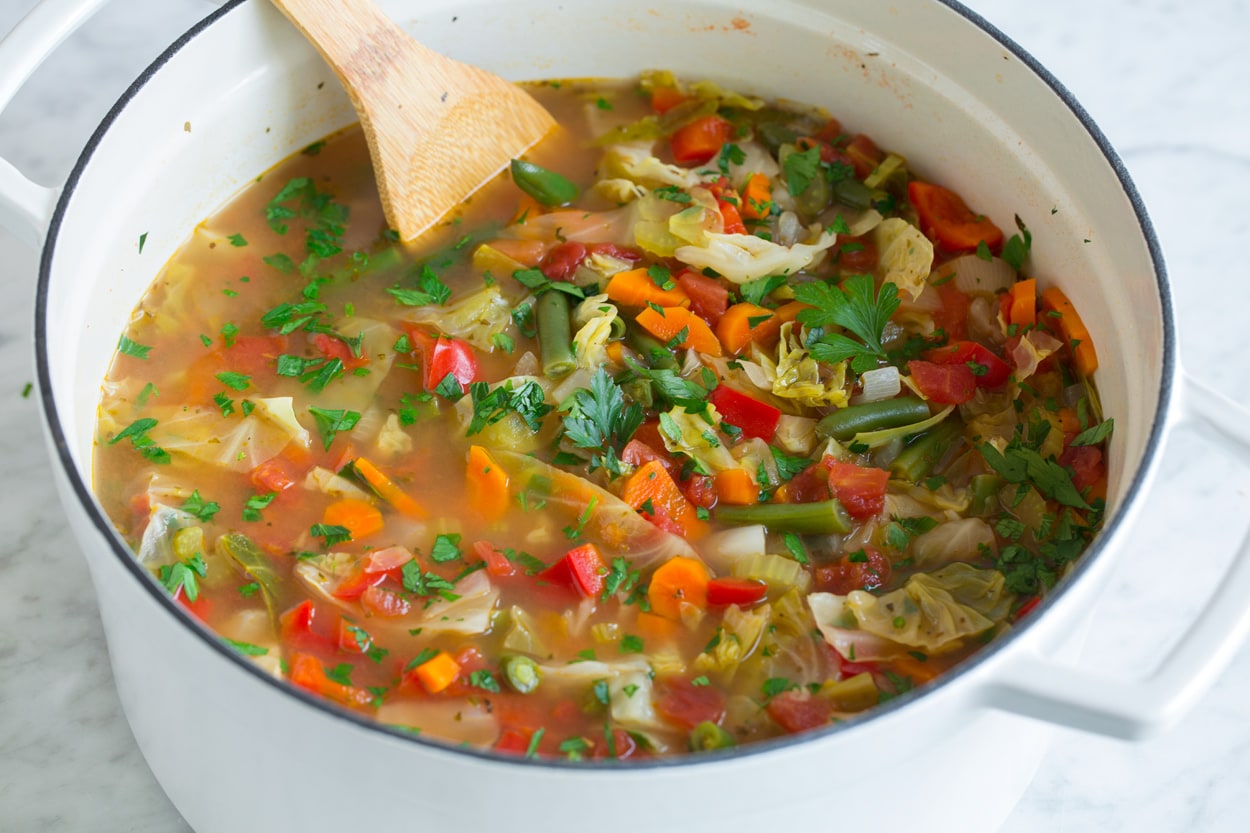 Cabbage Soup shown after finished cooking in large white pot.