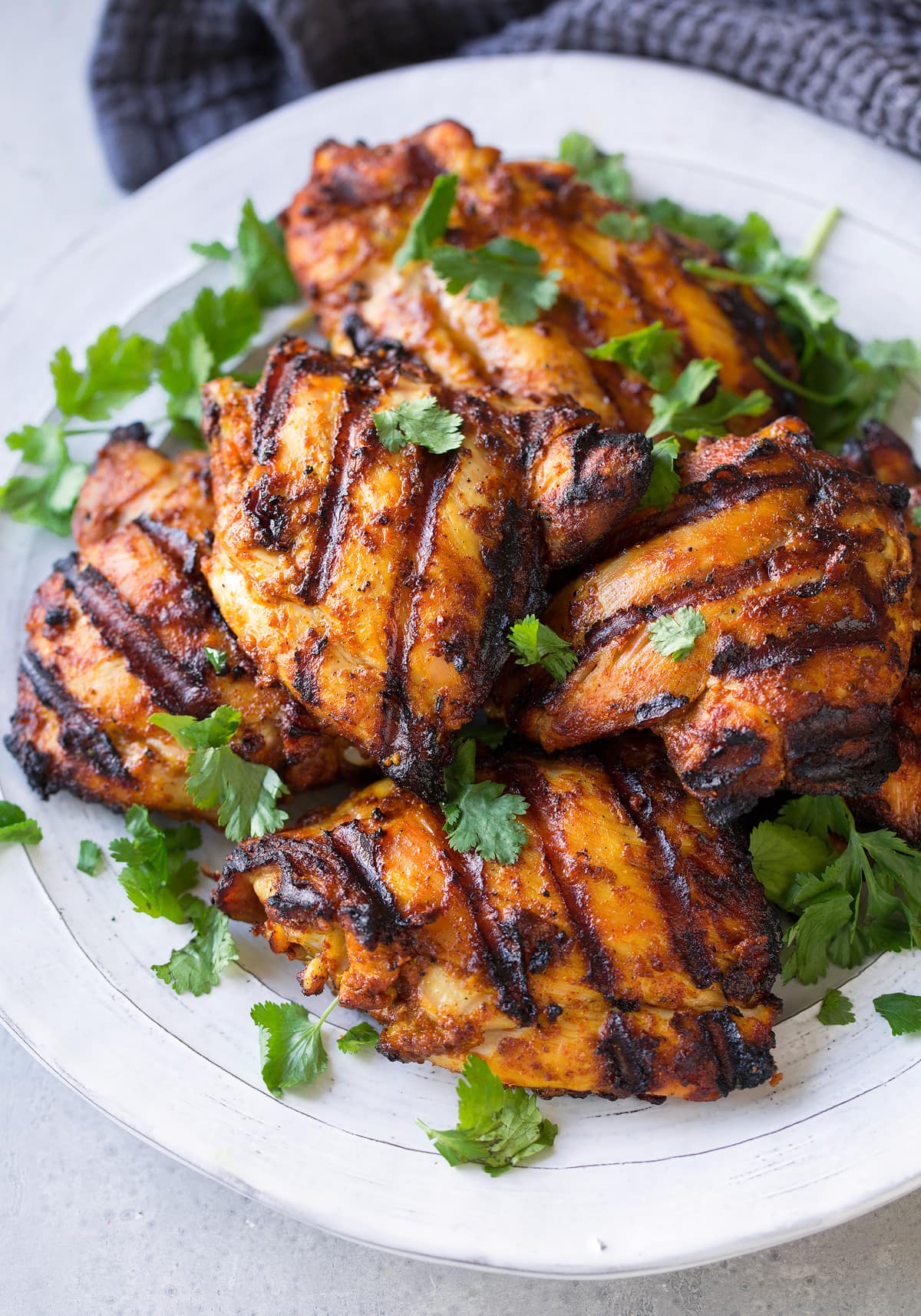 Platter full of Tandoori Chicken pieces garnished with cilantro.