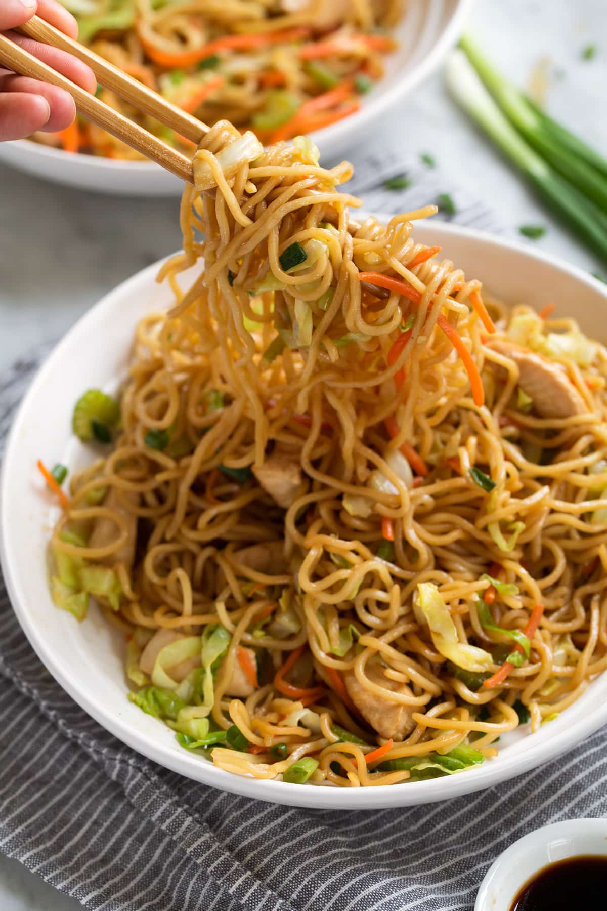 Scooping chow mein with chop sticks.