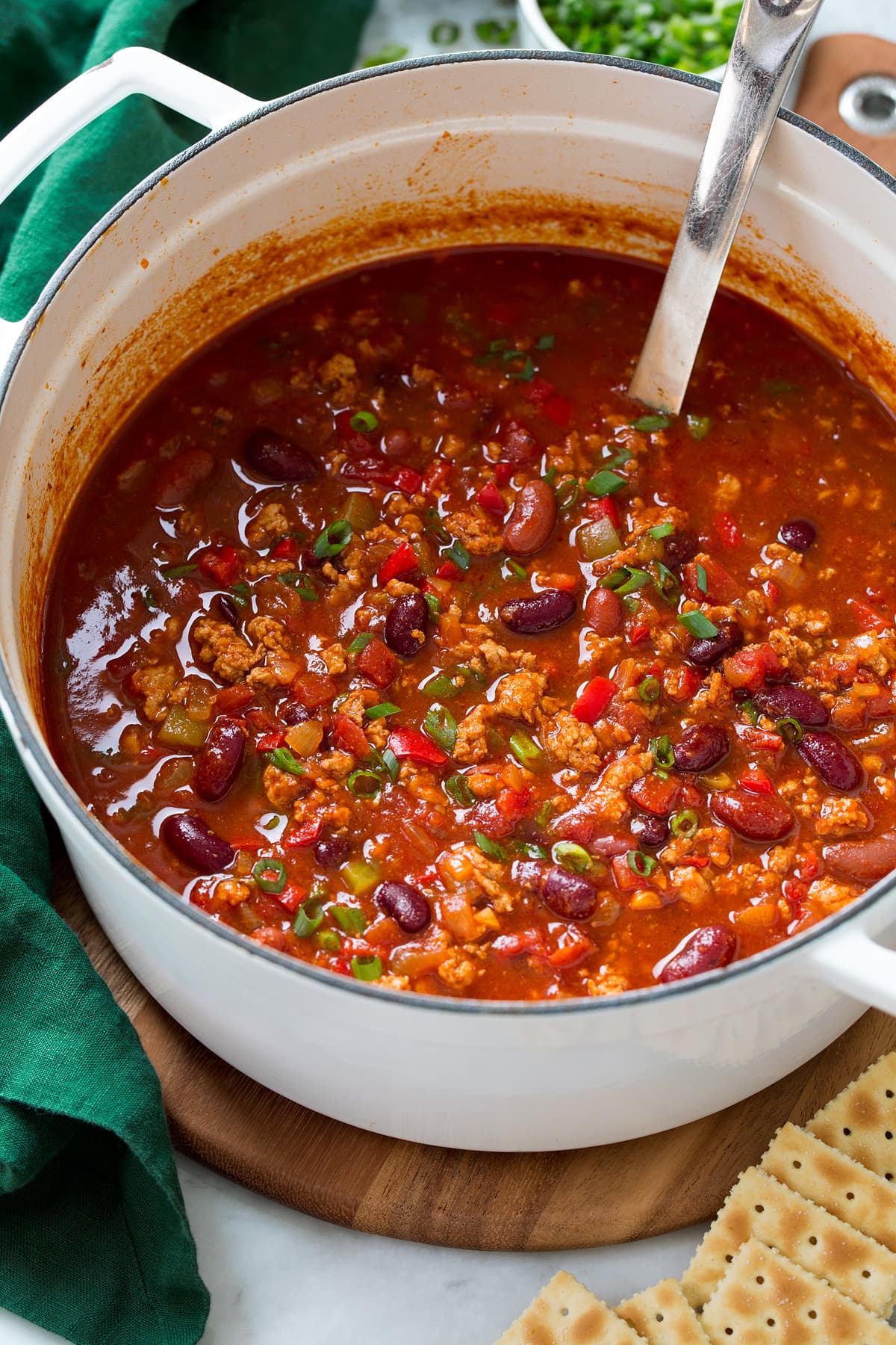 A white pot filled with turkey chili.