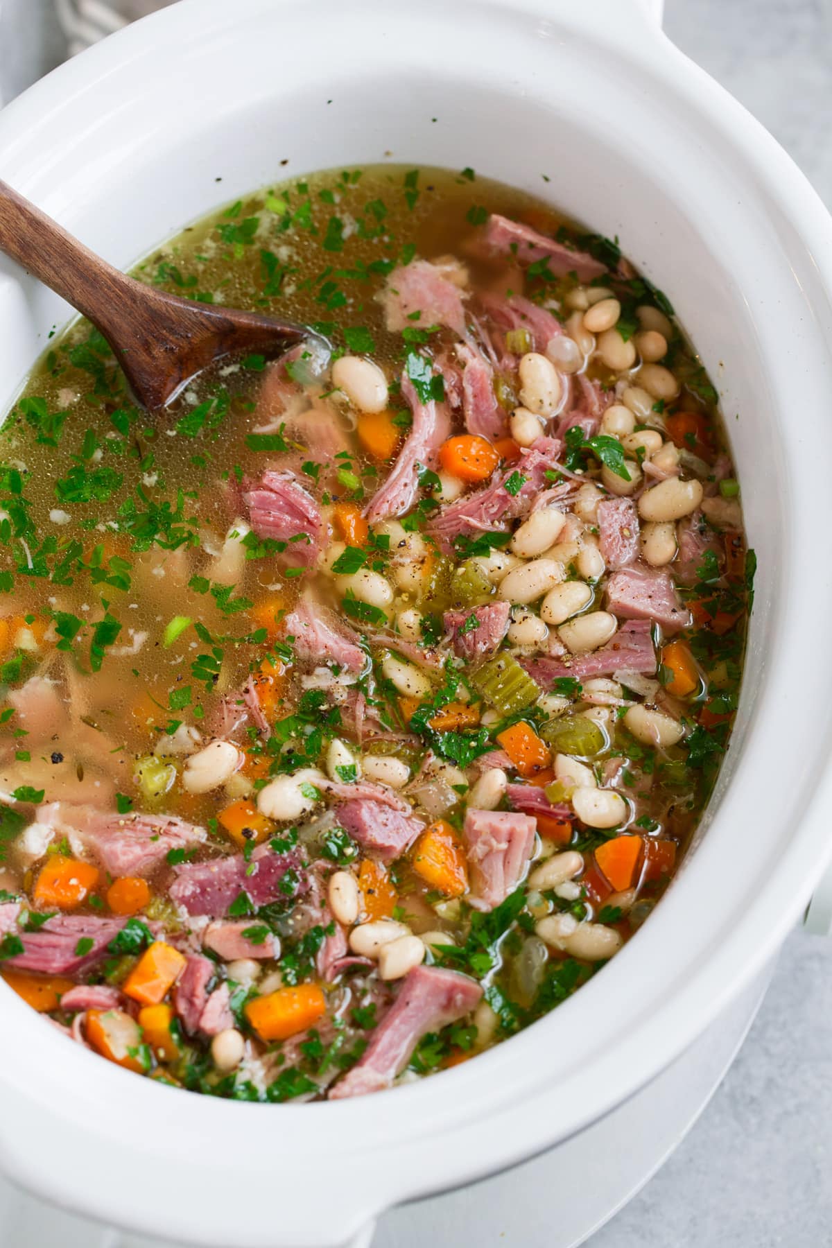 Ham and Bean Soup Ham and bean soup shown in a white slow cooker after cooking.