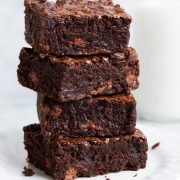 Stack of brownies on a white dessert plate.
