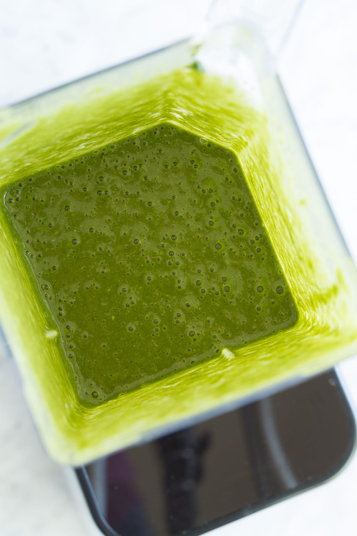 My go-to Green Smoothie! Healthy and perfectly filling. Made with spinach, berries, bananas, oats and almonds. #smoothie #greensmoothie #healthy #breakfast #smoothie Green smoothie in blender after pureeing.