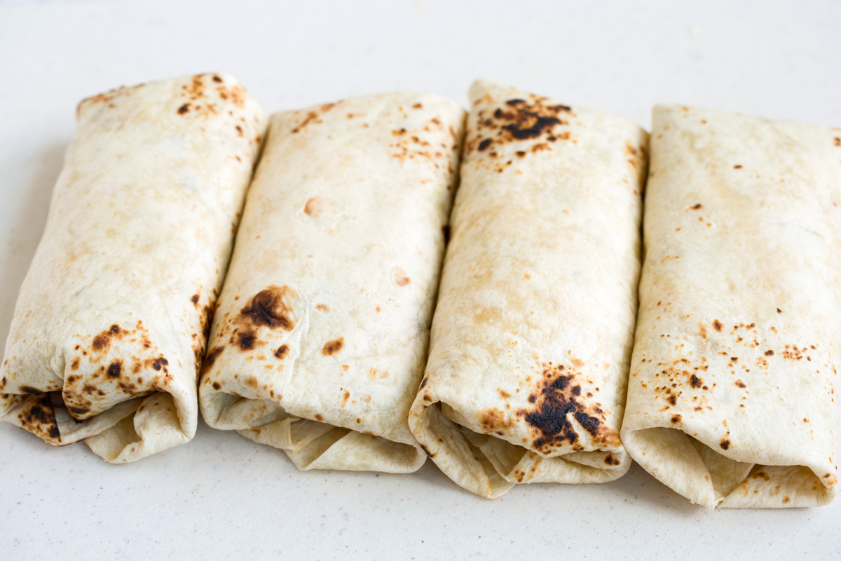 Breakfast Burritos Four wrapped up breakfast burritos.