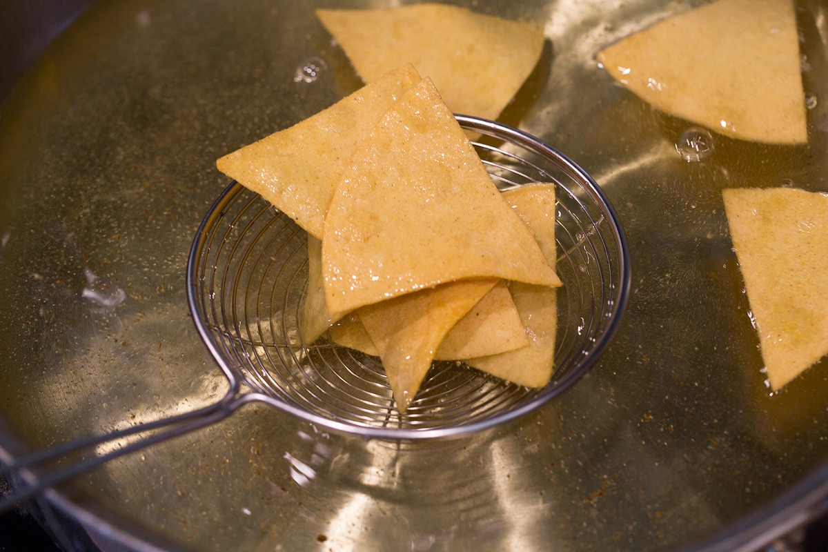 Homemade Tortilla Chips Draining tortilla chips through a wire spider.