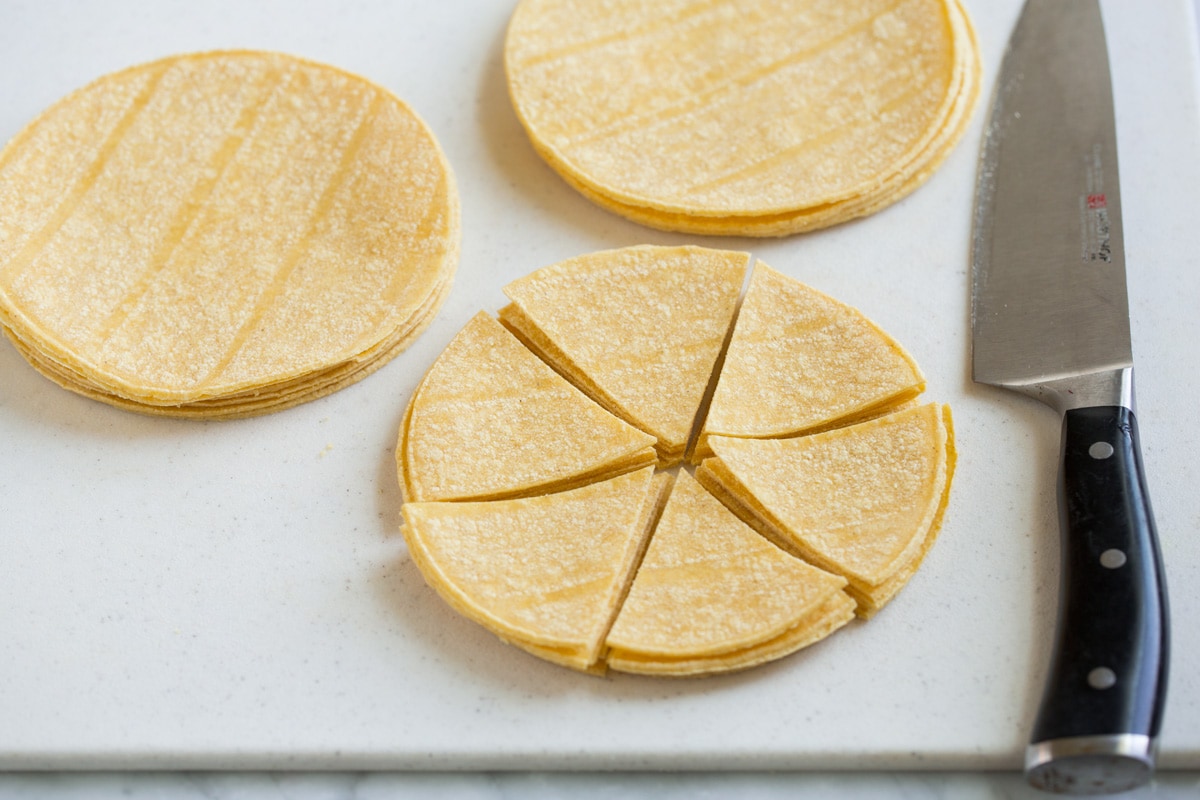 Homemade Tortilla Chips Cutting tortilla stacks into wedges.