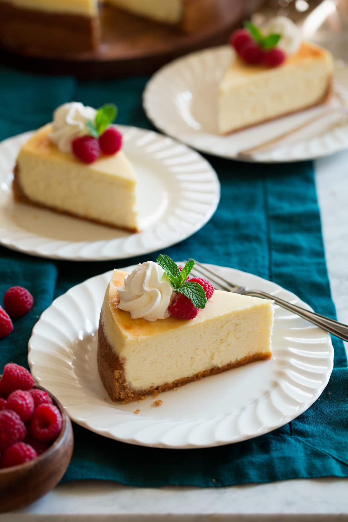Three slices of cheesecake on dessert plates.