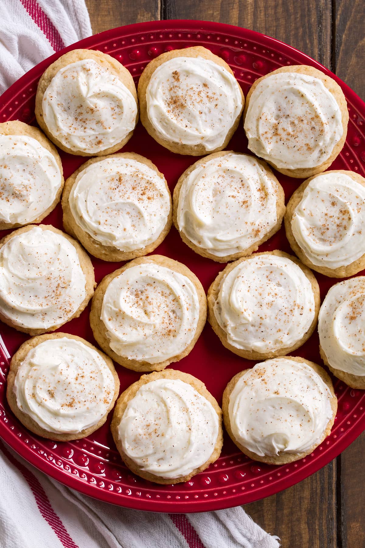 Red plate full of 14 frosted eggnog cookies.