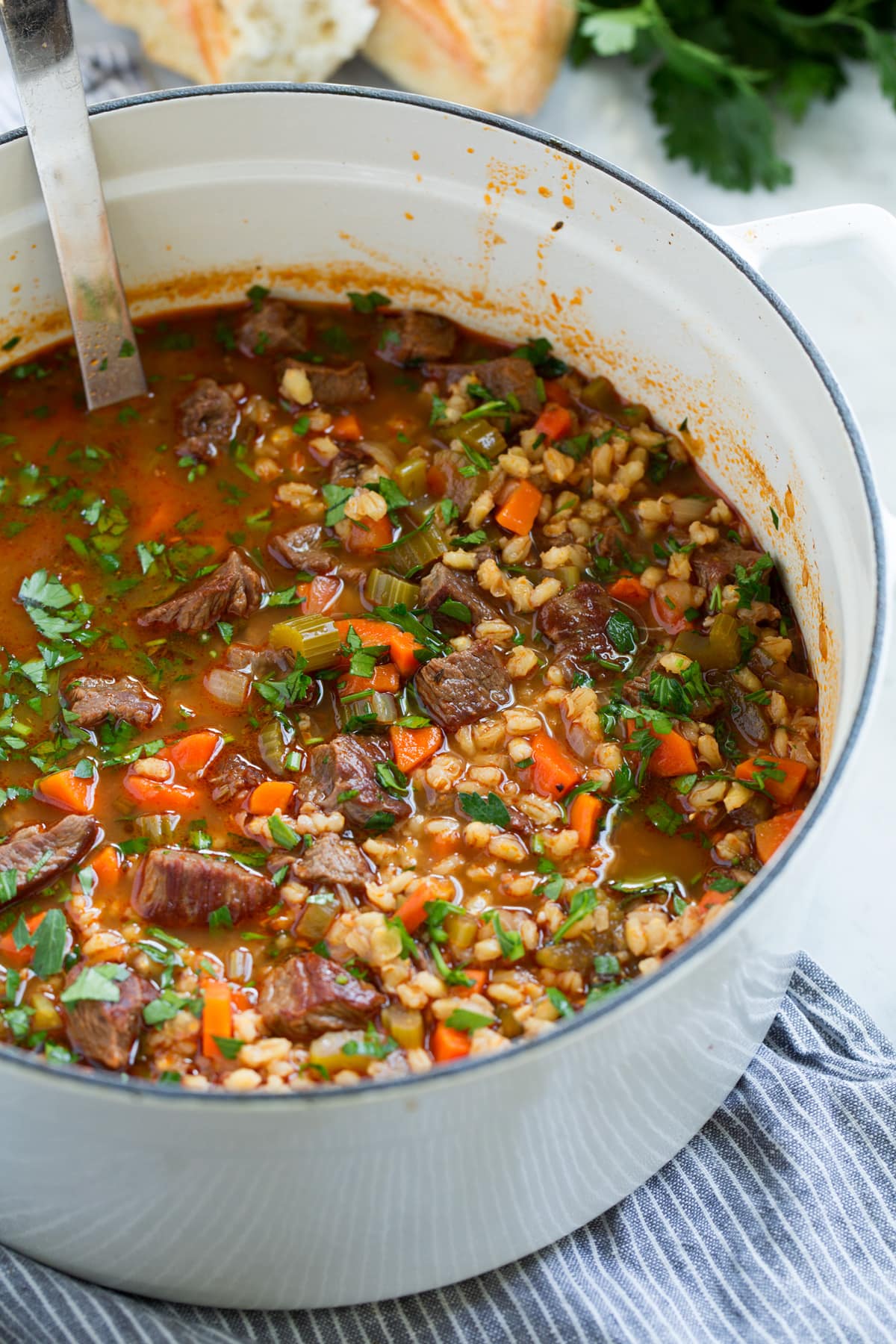 White pot filled with beef and barley soup
