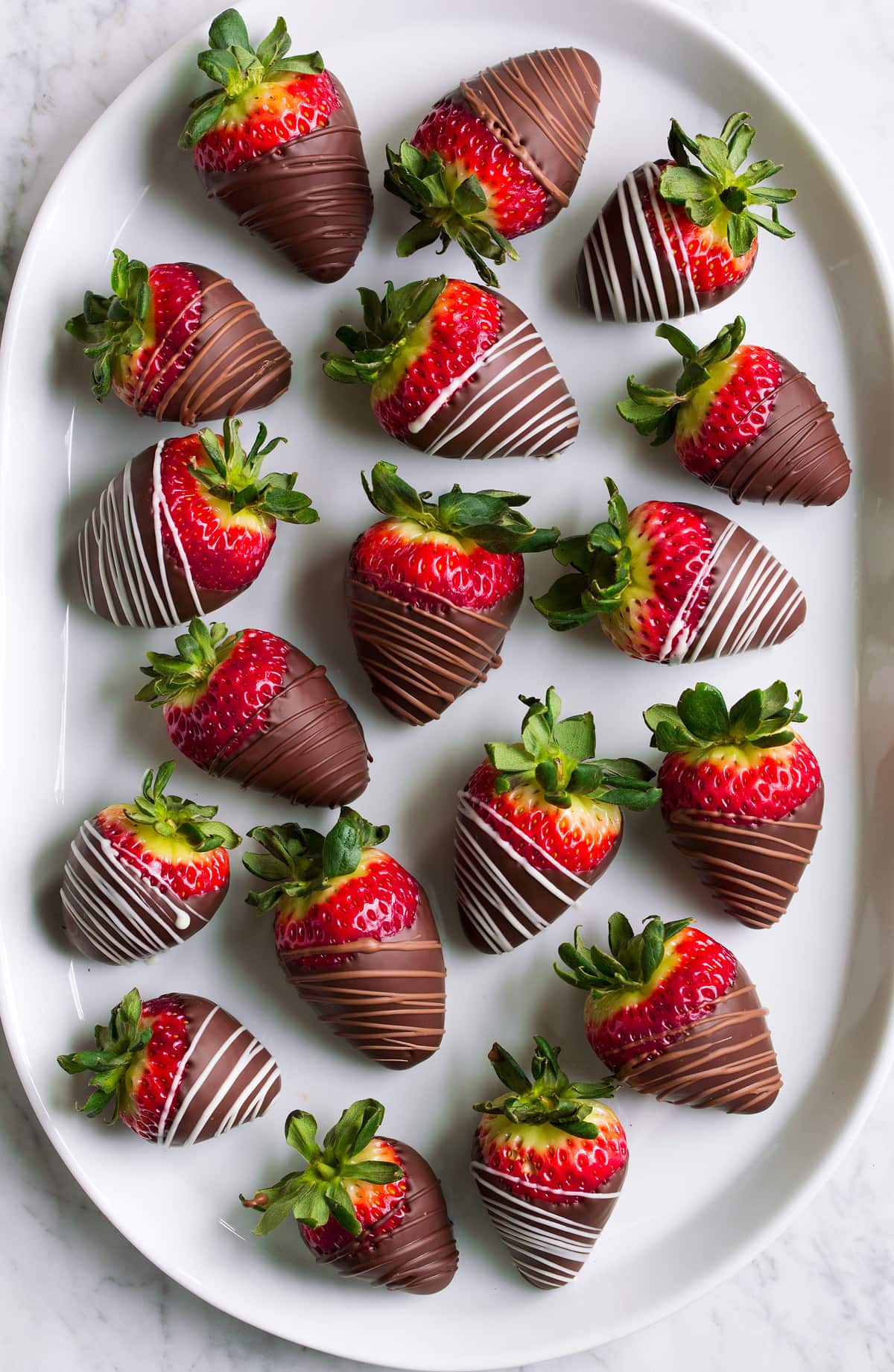 Chocolate Covered Strawberries Chocolate dipped strawberries on an oval white platter.