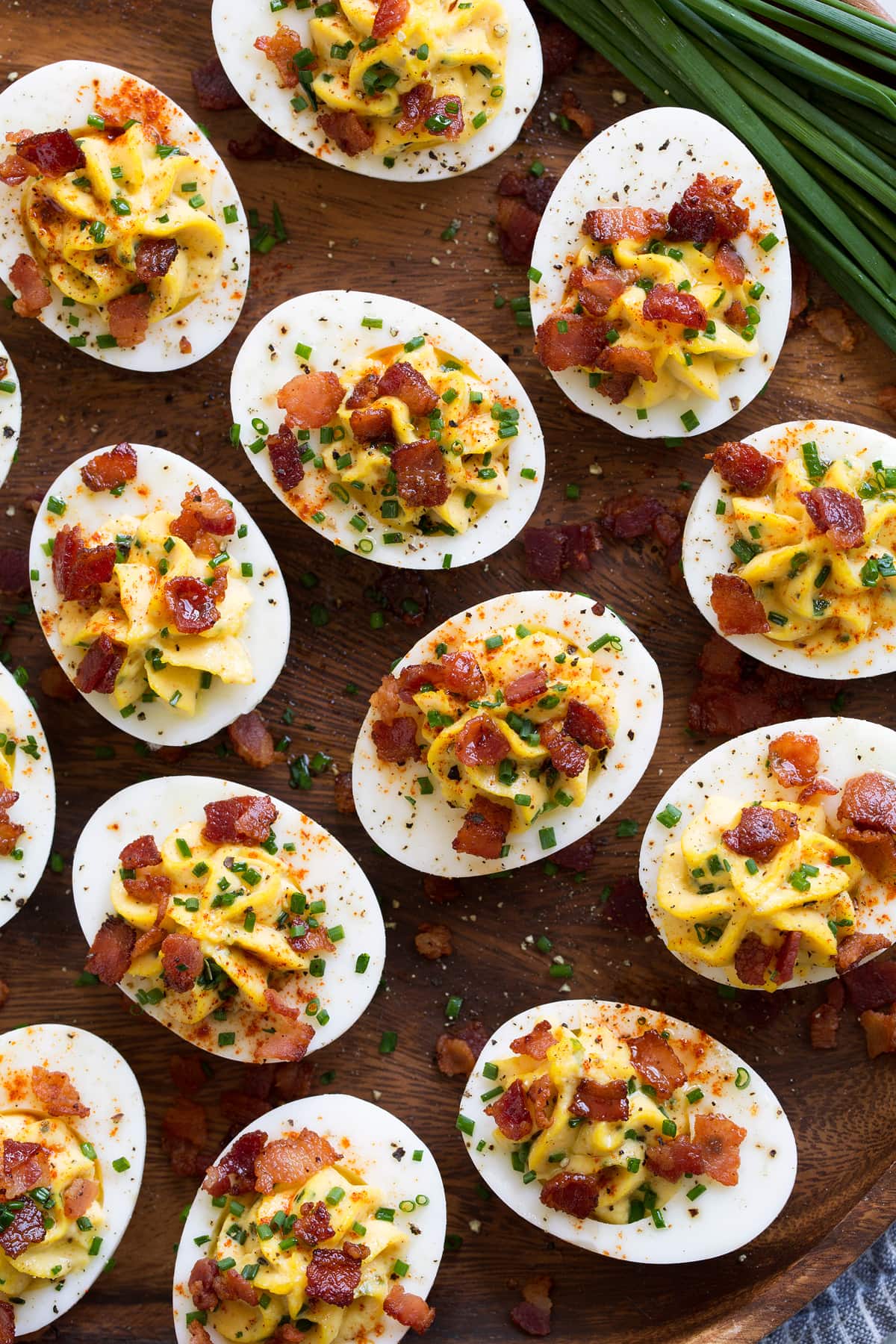 Garnished deviled eggs shown overhead with chives to the side.