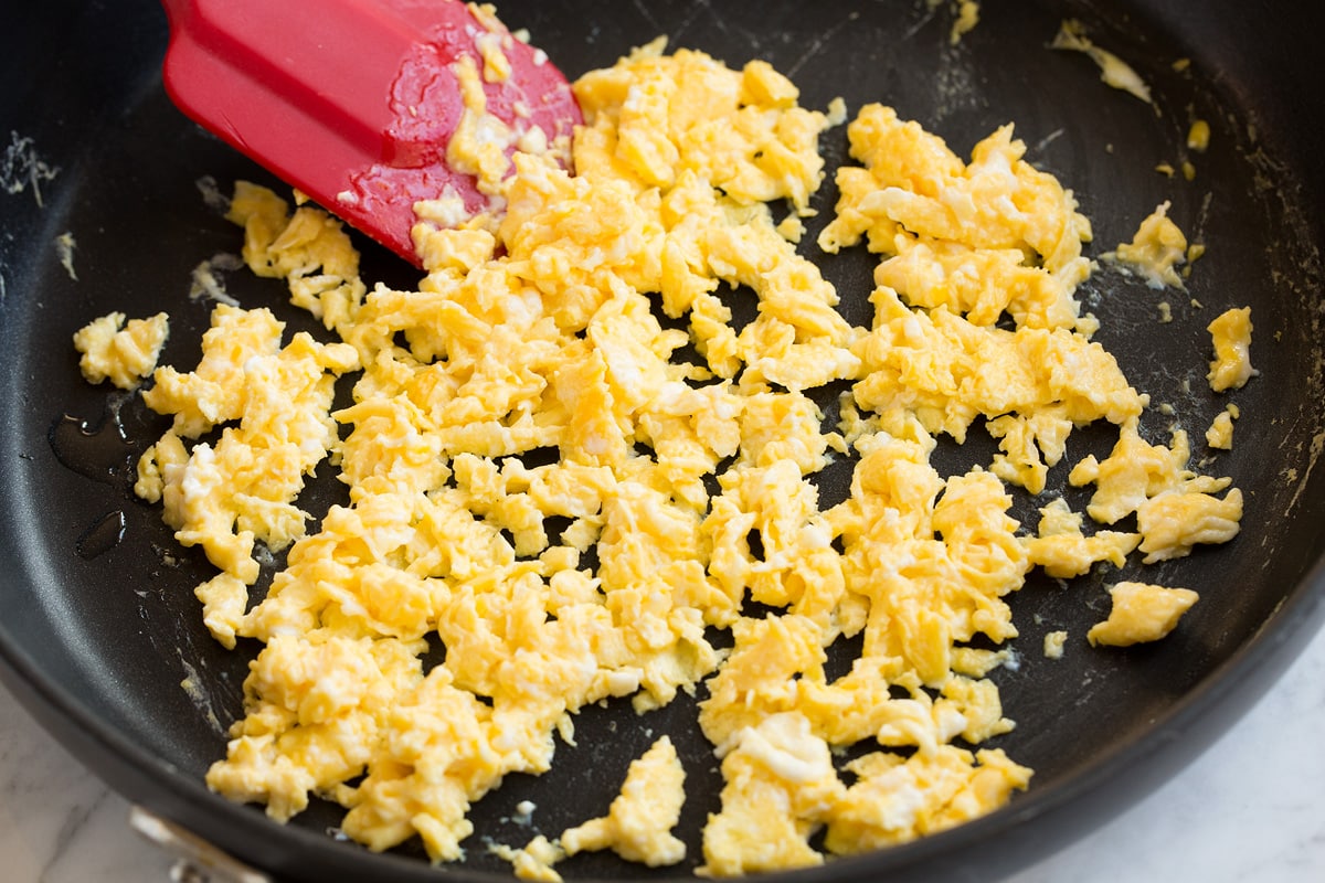 A classic, easy to make recipe! This is filled with tender rice, colorful vegetables, hearty eggs, tender (optional) ham and it's all fried with a delicious stir fry sauce. Scrambling and cooking eggs in a large skillet.
