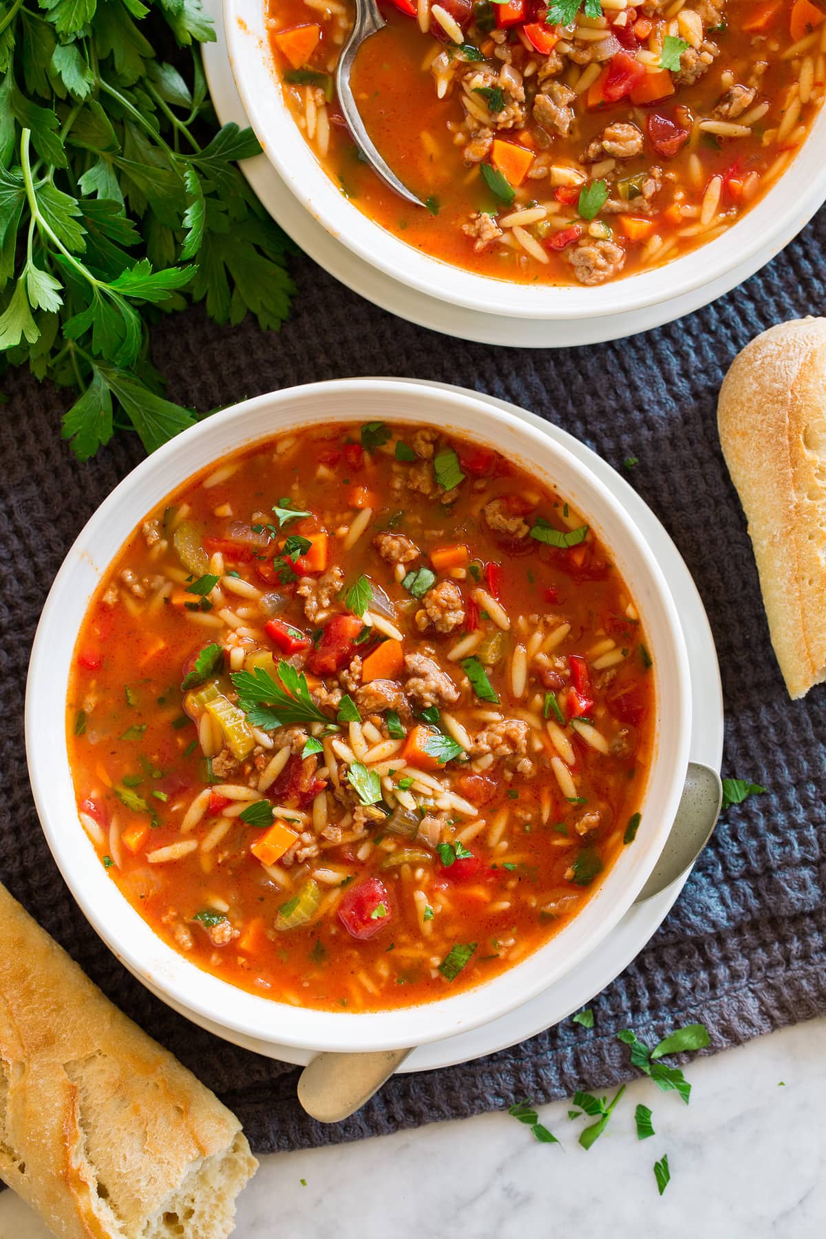 Two servings of sausage soup shown in bowls.