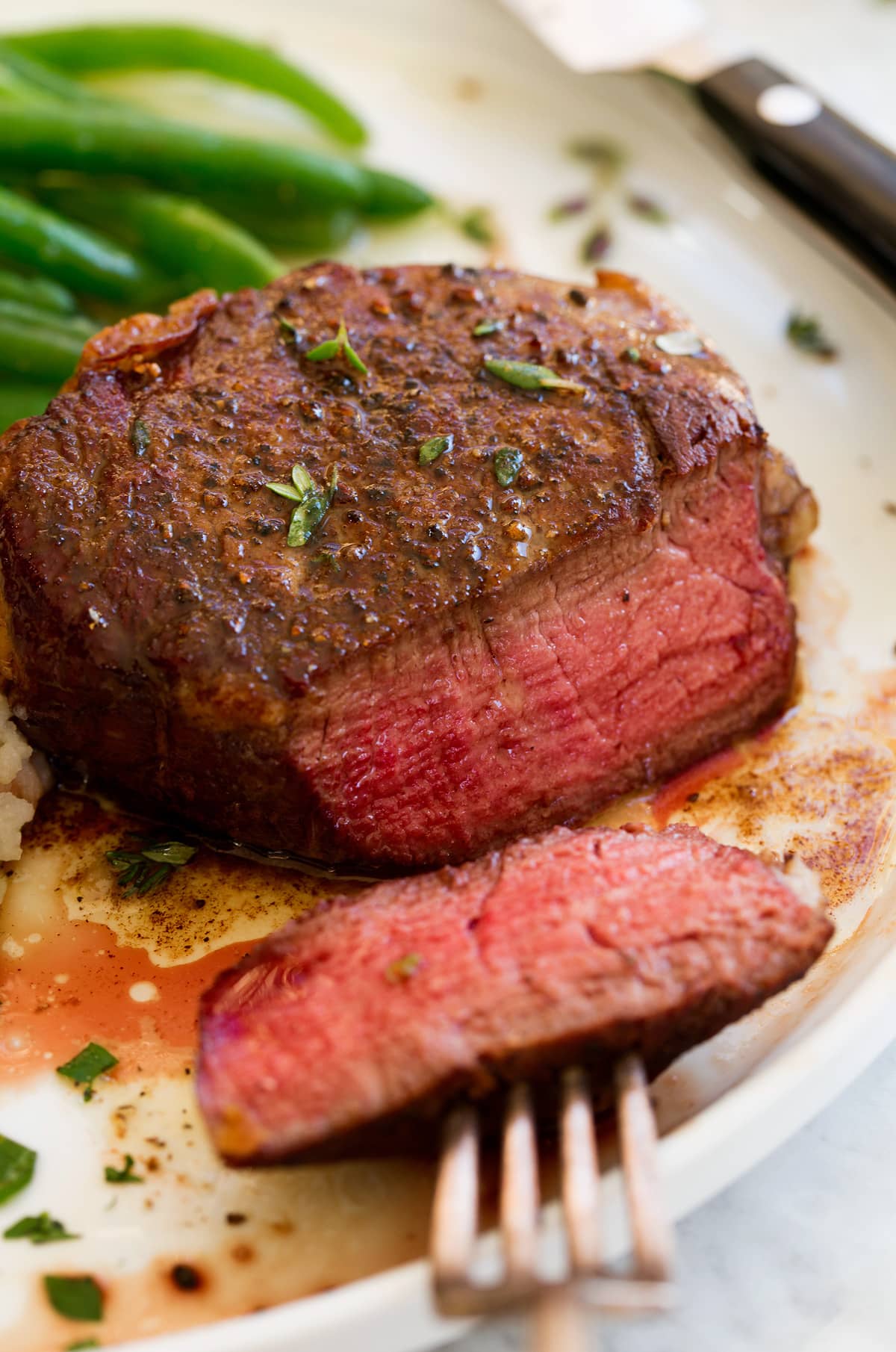 Close up image of filet mignon sliced to show medium rare interior.