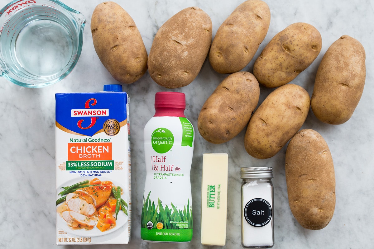 Crockpot Mashed Potatoes Photo shows ingredients used to make crockpot mashed potatoes. Includes russet potatoes, butter, salt, half and half, chicken broth and water.