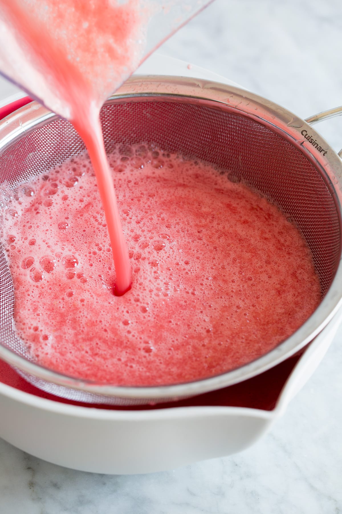 Aqua Fresca Photo: Watermelon aqua fresca being draing in a large bowl.