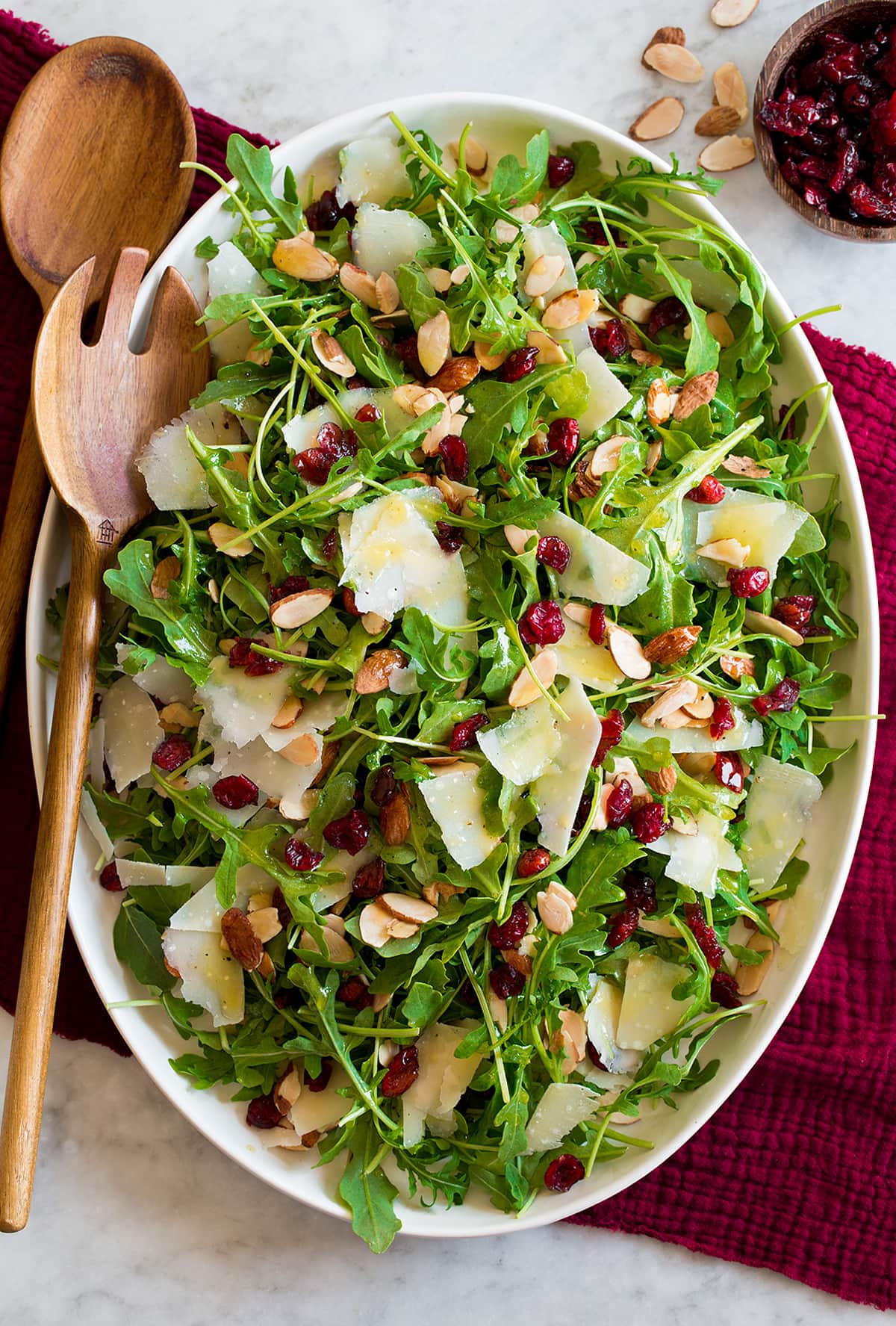 Arugula Salad Arugula salad on a white oval platter over a red cloth.