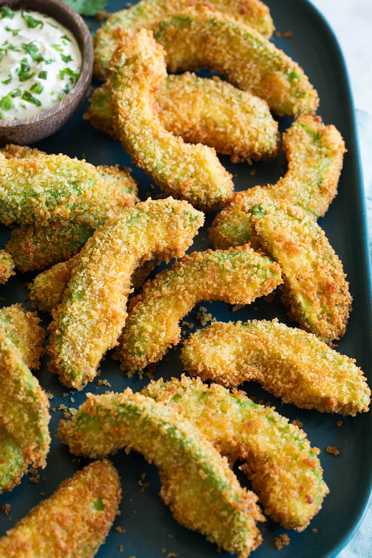 Avocado Fries Avocado fries shown piled on a platter from a side angle.