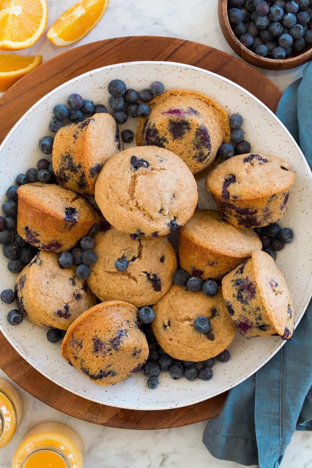 Healthy Blueberry Muffins Serving bowl full of healthy blueberry muffins and fresh blueberries.