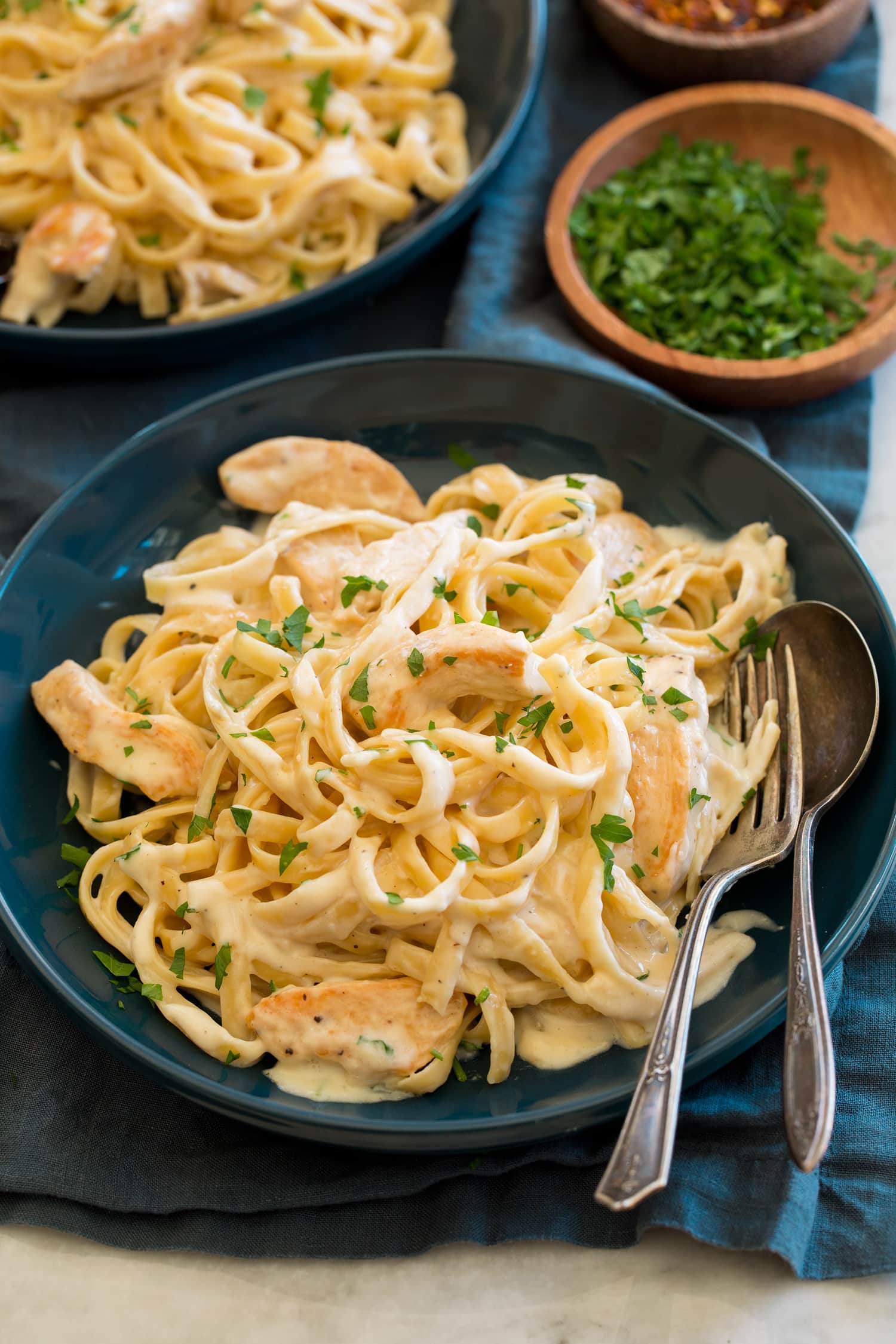 Chicken alfredo in a blue pasta bowl.