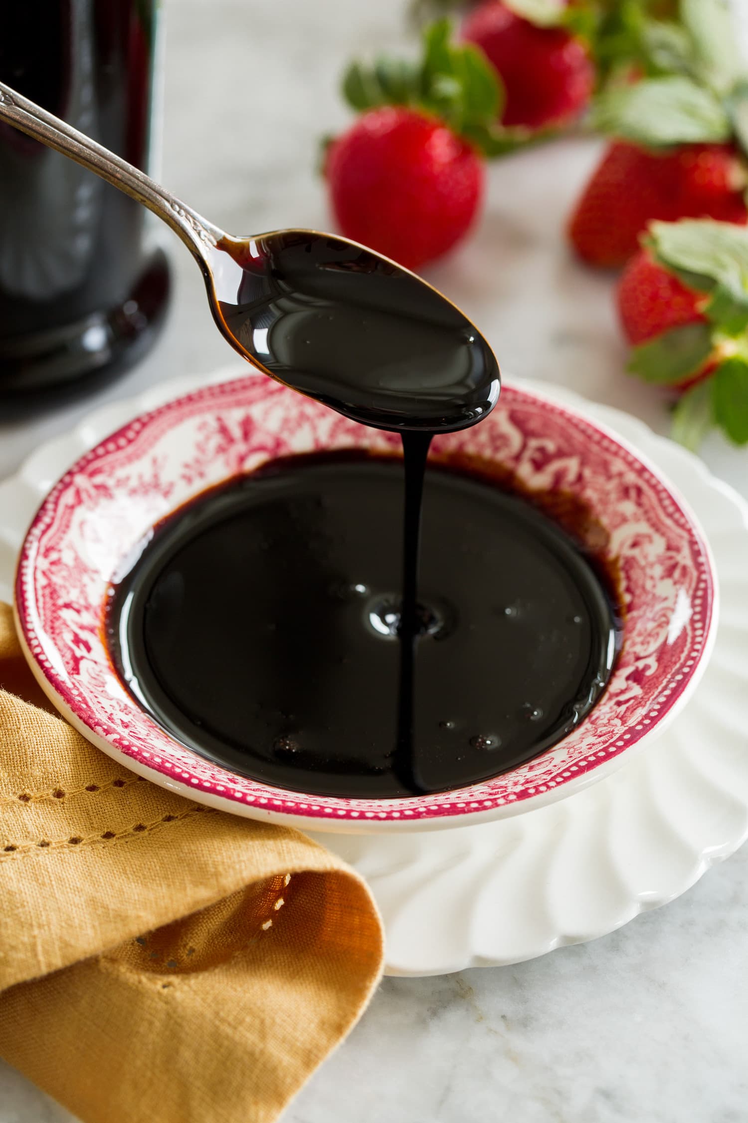 Balsamic Glaze Balsamic glaze drizzled from a spoon into a small dish.