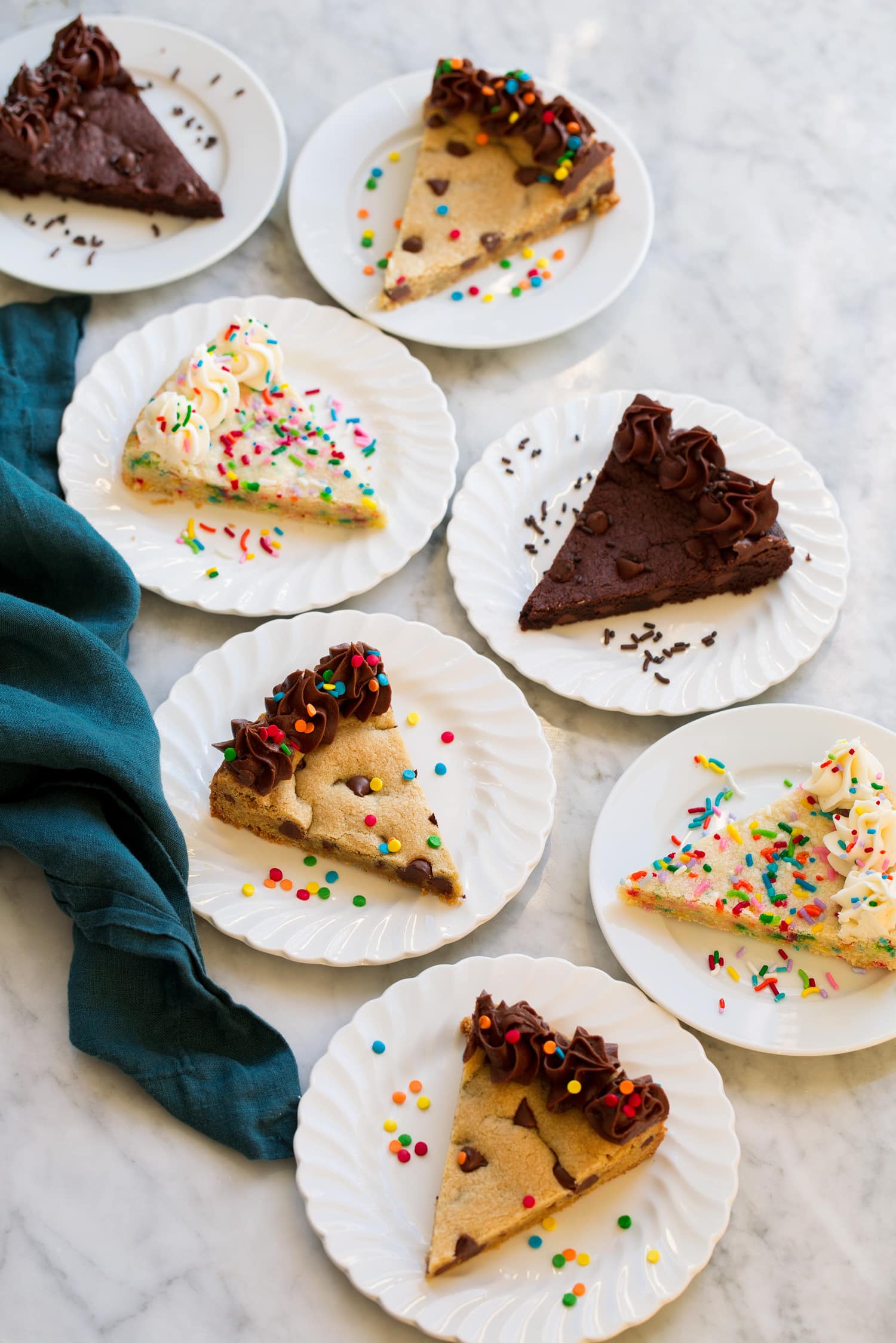 Cookie Cakes Slices of various flavors of cookie cakes on dessert plates.