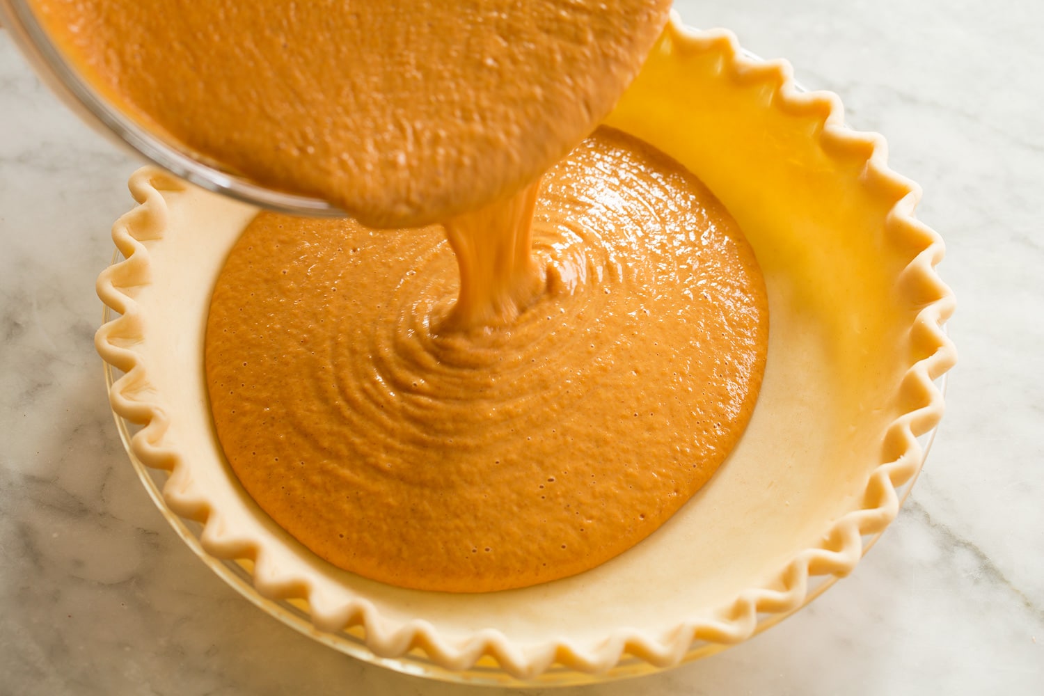 Filling being poured into pie crust.