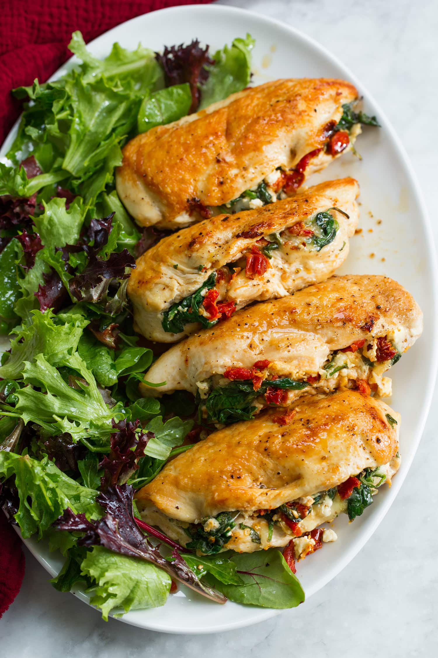 Stuffed Chicken Breasts Stuffed chicken breasts on a platter with a side salad.