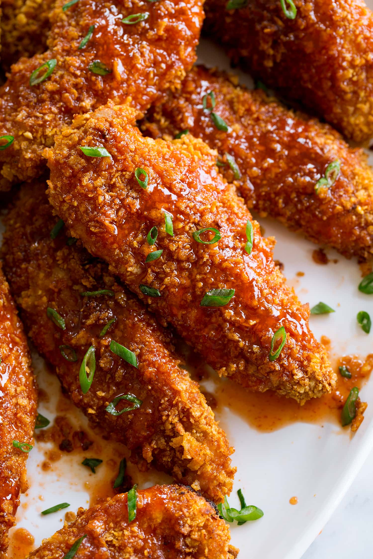 Hot Honey Chicken Close up photo of chicken strip coated in hot honey sauce.