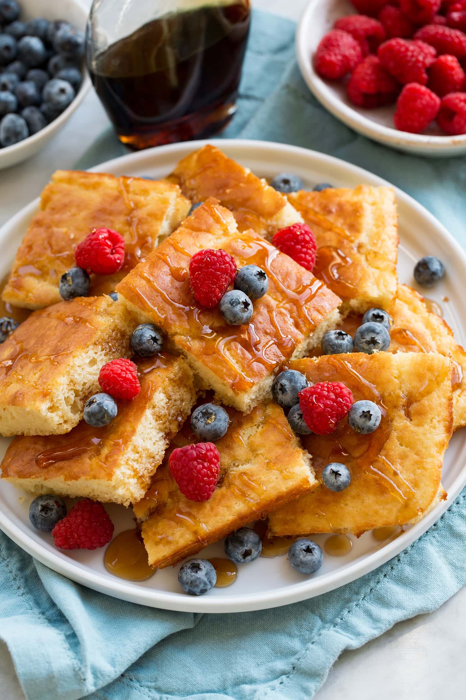 Sheet Pan Pancakes Slices of sheet pan pancakes piled with fruit.