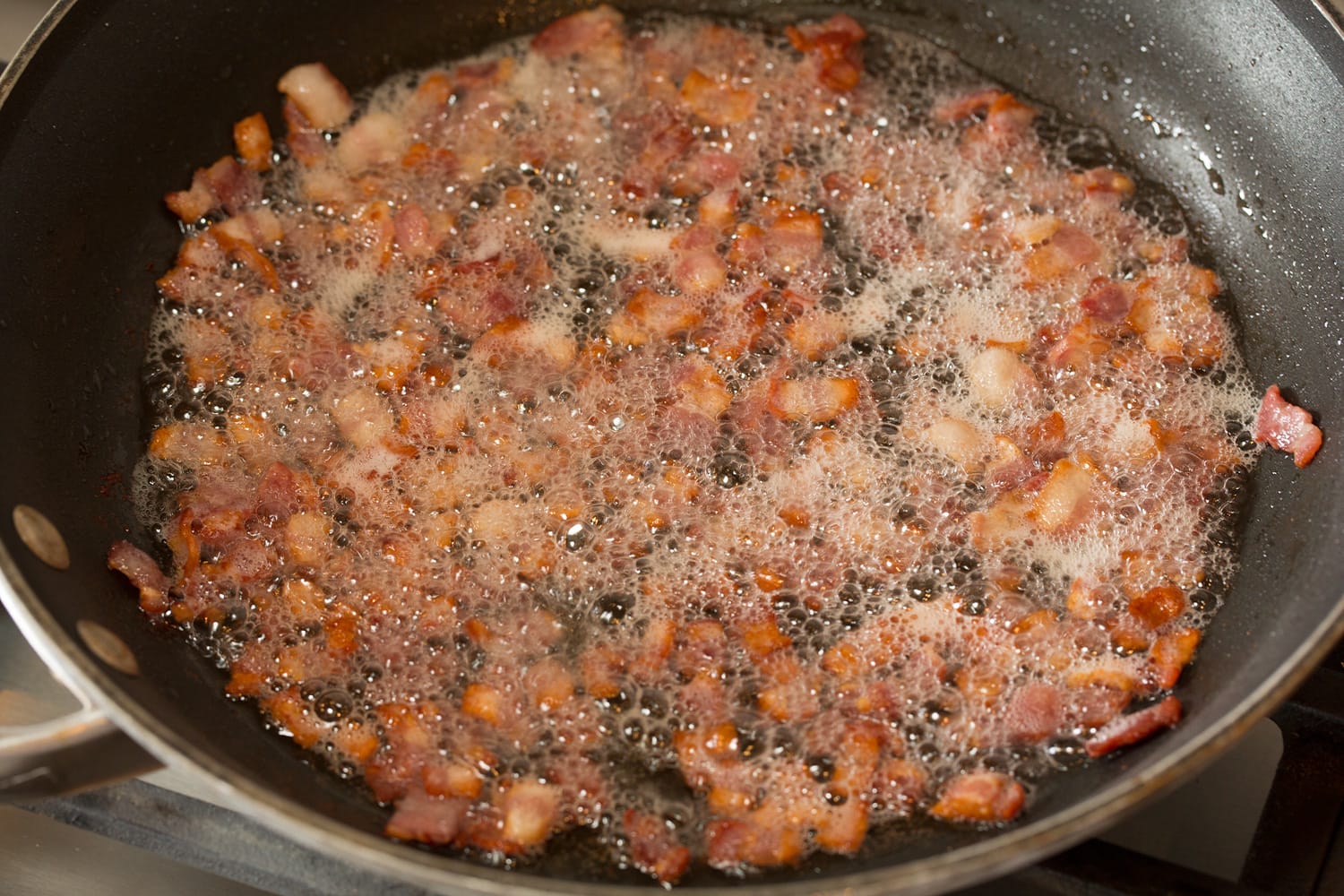 Pea Salad Cooking bacon in a skillet.