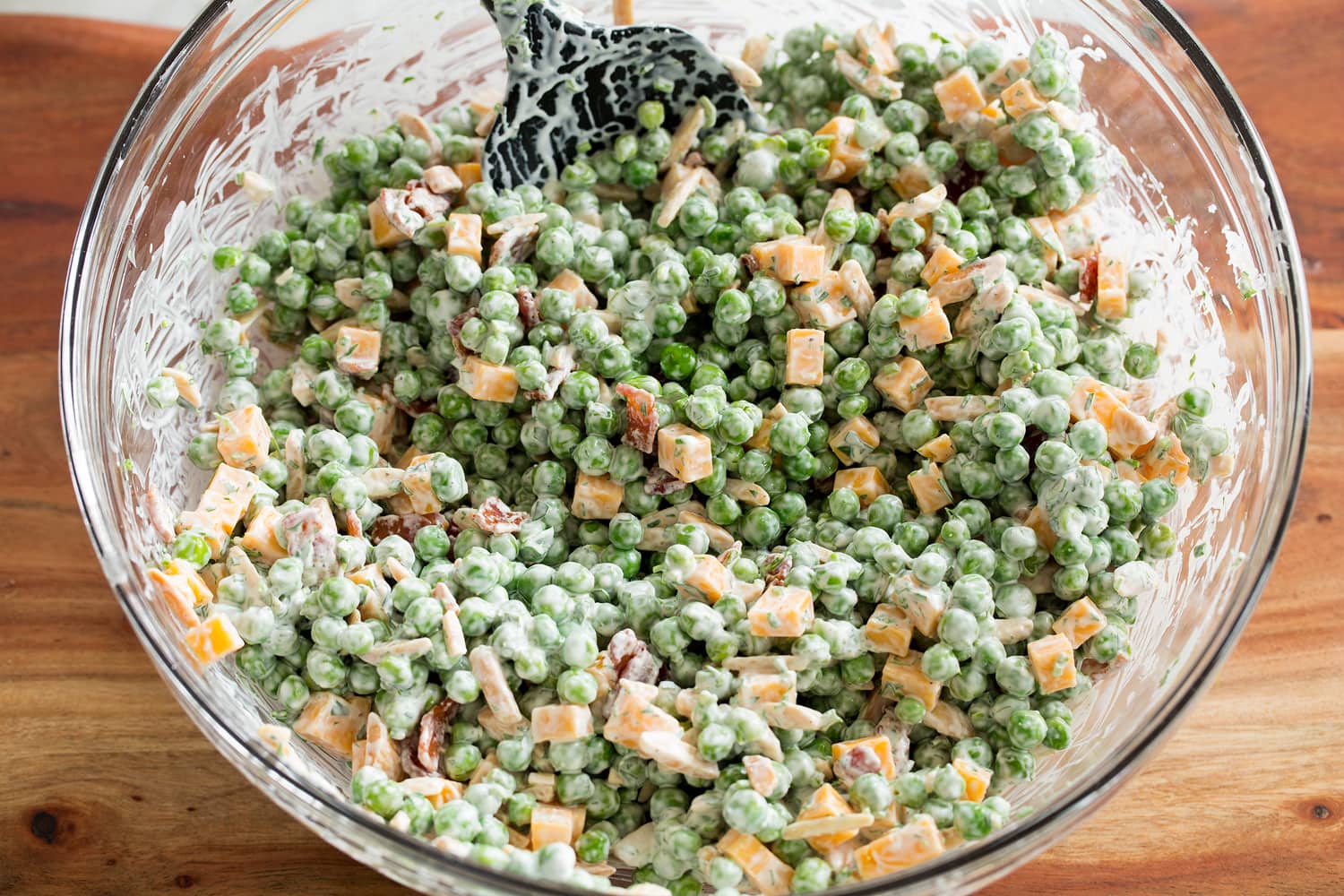 Pea Salad Completed pea salad in a glass mixing bowl.