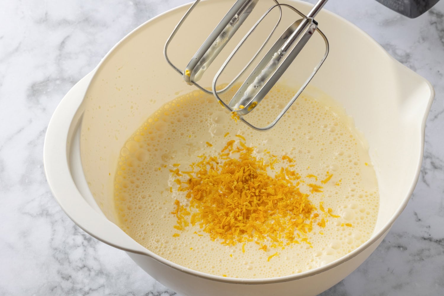 Lemon Icebox Pie Lemon zest added to mixture in mixing bowl.