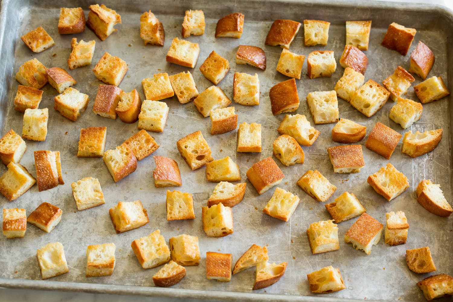 Panzanella Salad Toasted bread cubes on a baking sheet.