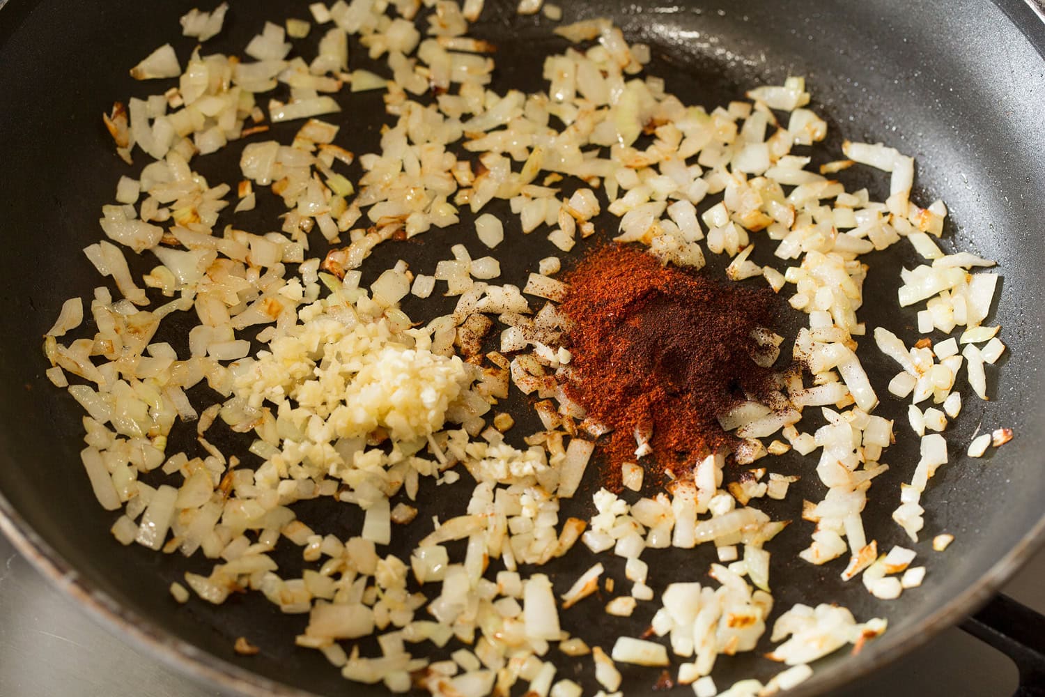 Huevos Rancheros Sauteed onions with garlic and chili powder in skillet.