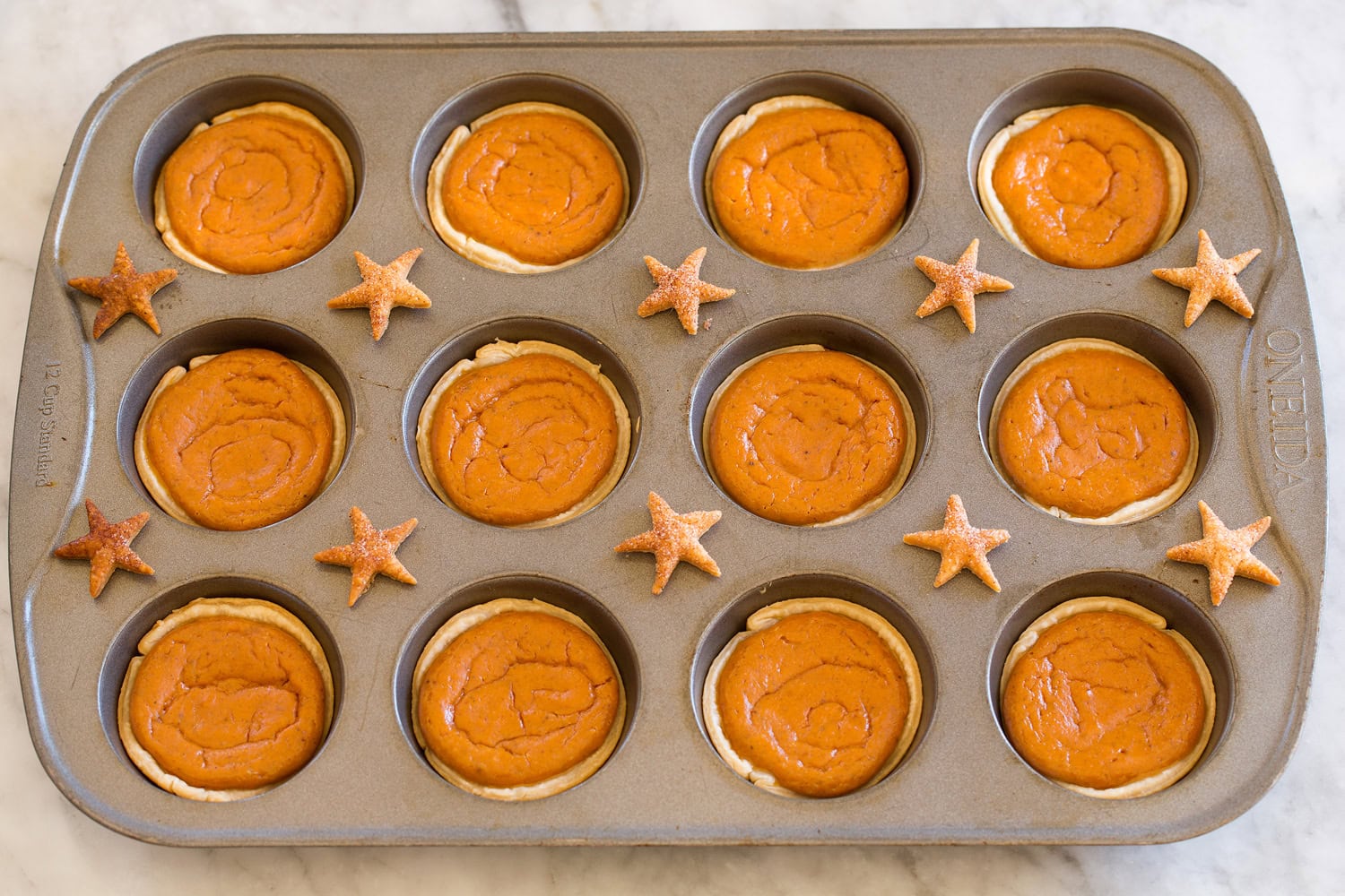 Mini Pumpkin Pies Pumpkin pies shown after baking in muffin pan.