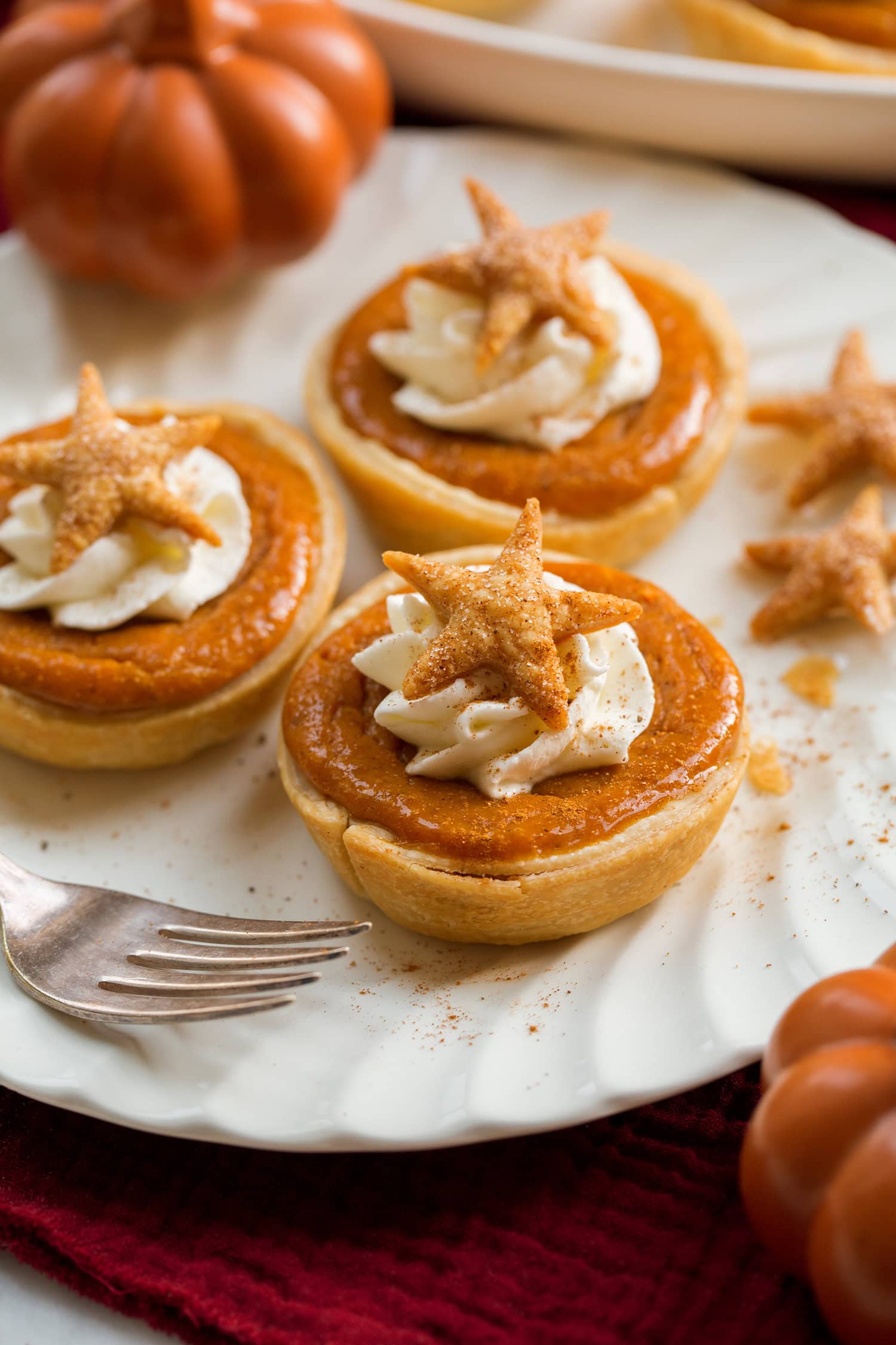 Mini Pumpkin Pies Three mini pumpkin pies on a white plate.