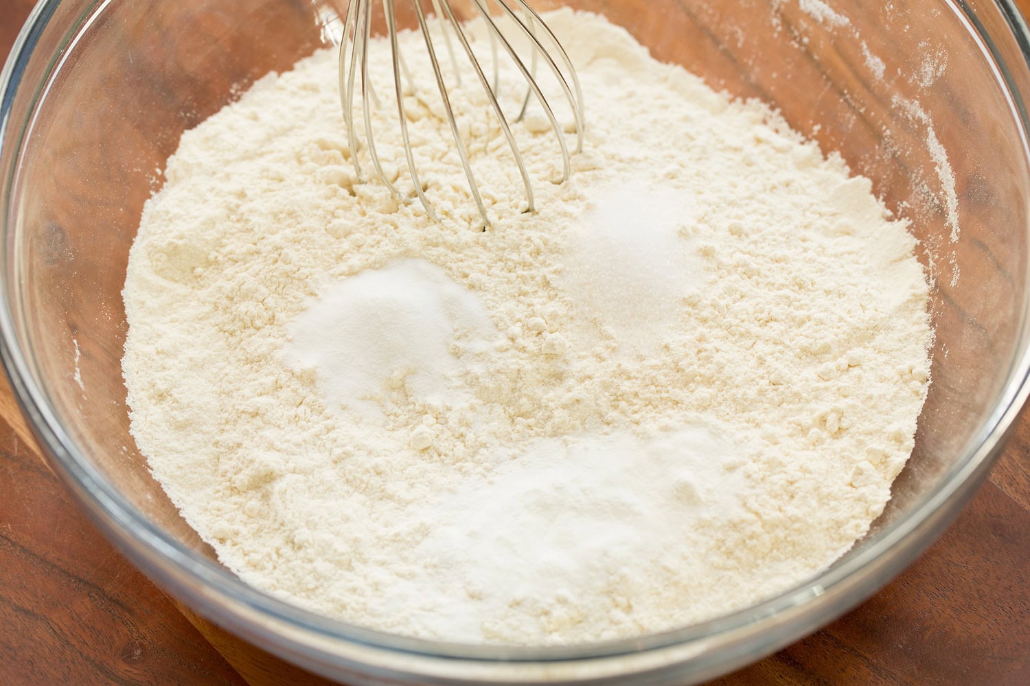 Lemon Cookies Flour mixture with baking powder, baking soda and salt in glass mixing bowl with whisk. First step of making lemon cookies.
