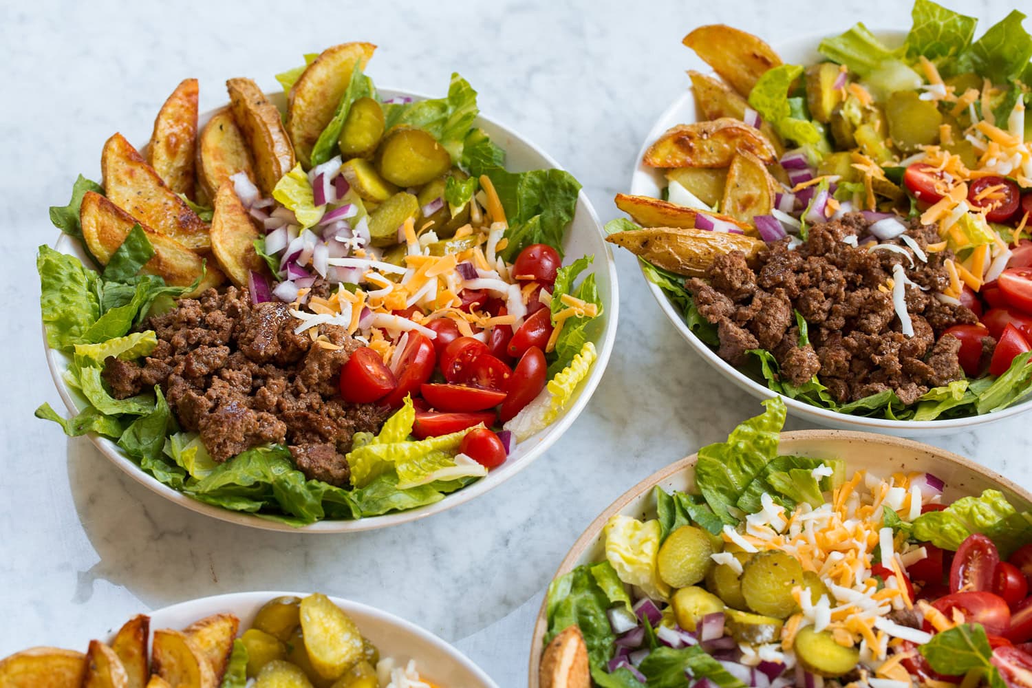 Burger Bowls Four assembled burger bowls showing how to layer.