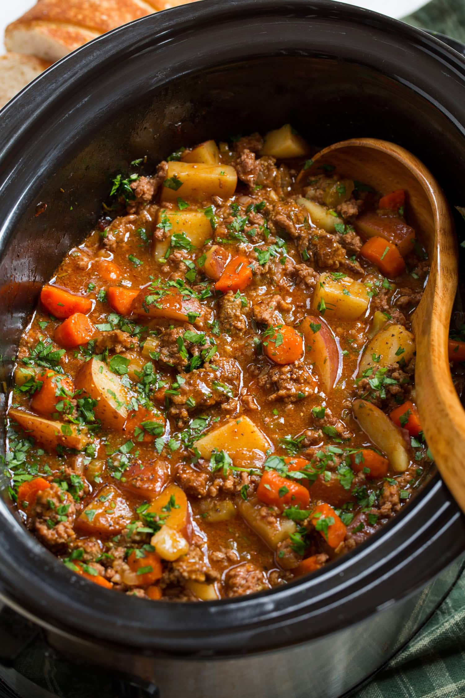 Slow Cooker Ground Beef Stew Ground beef stew with potatoes and carrots in a slow cooker.