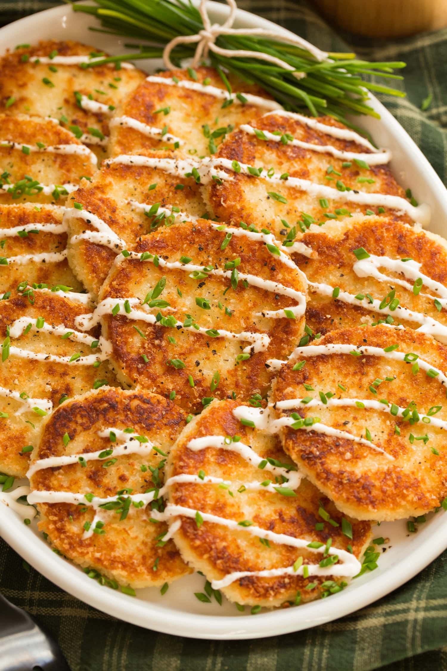 Mashed potato cakes covered with panko, drizzled with sour cream and garnished with chives.
