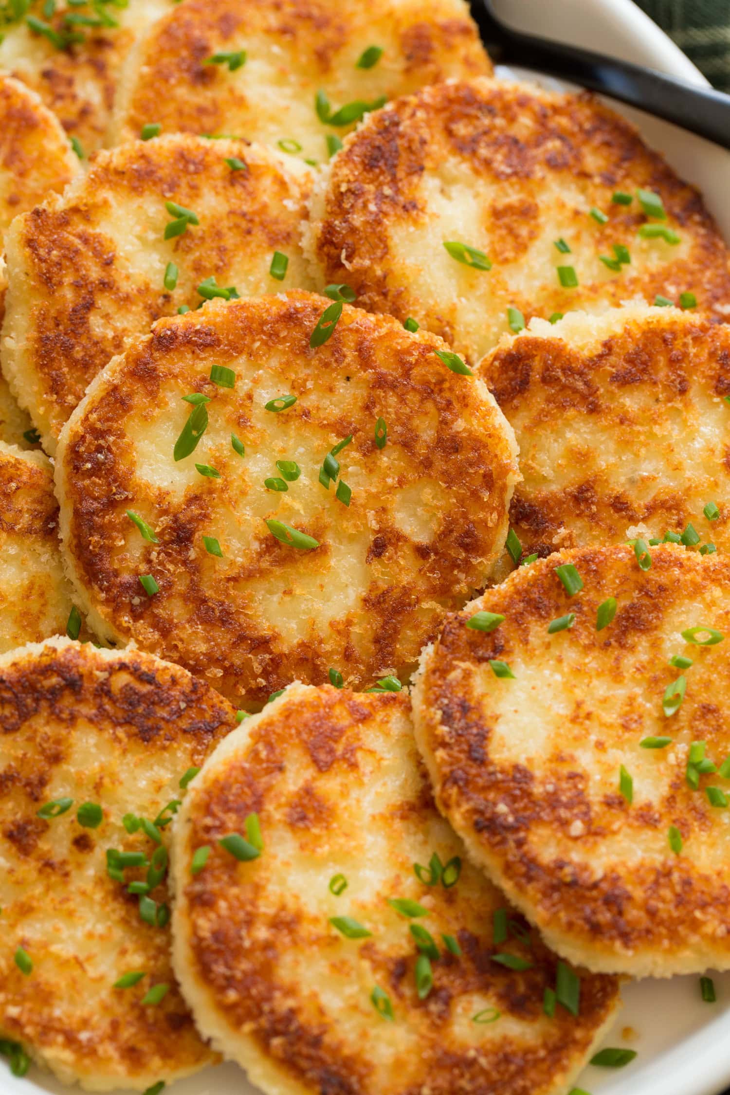 Close up photo mashed potato cakes showing panko bread crumbs and browned exterior.