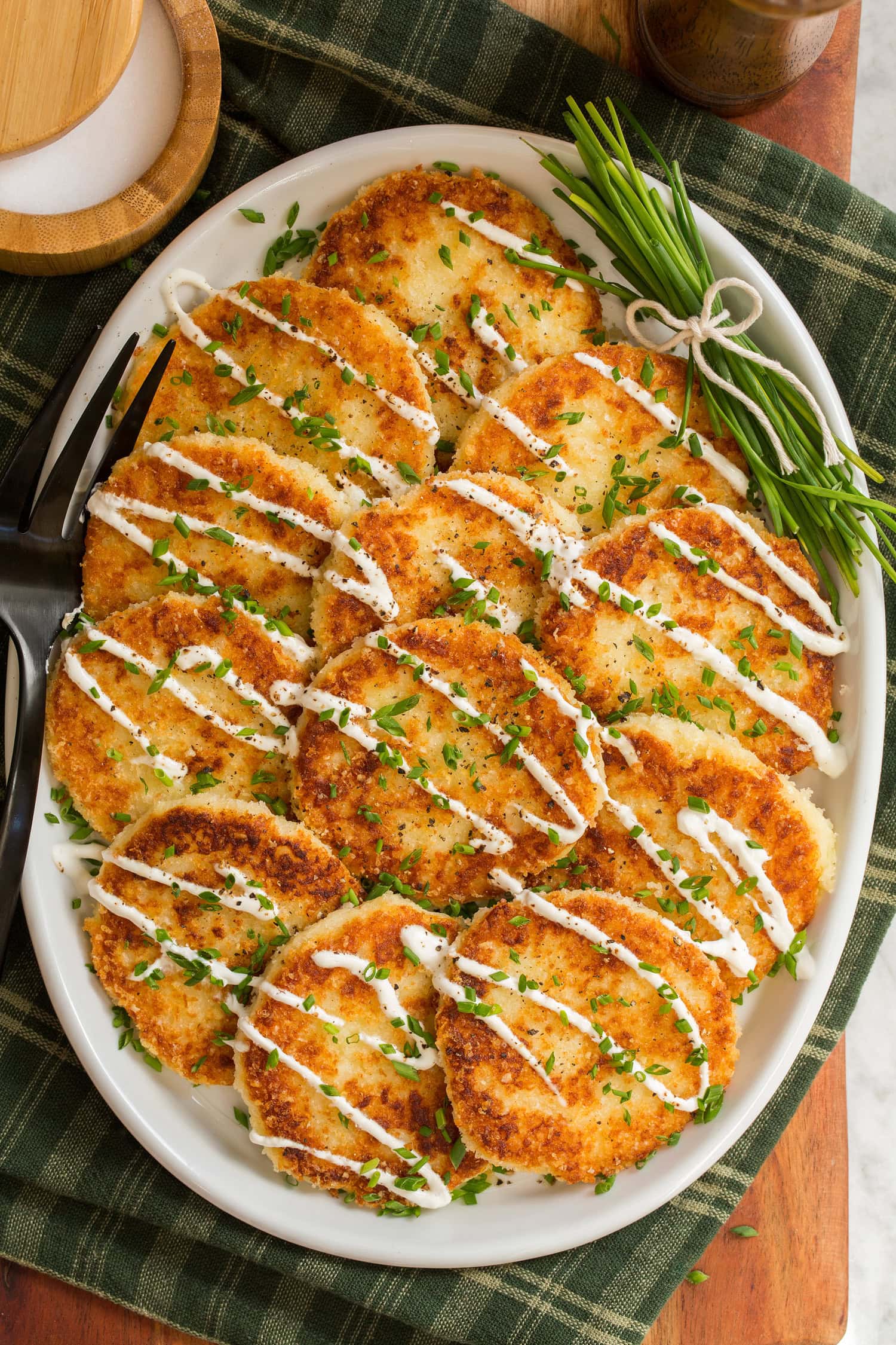 Overhead photo mashed potato cakes layered overlapping on a platter.